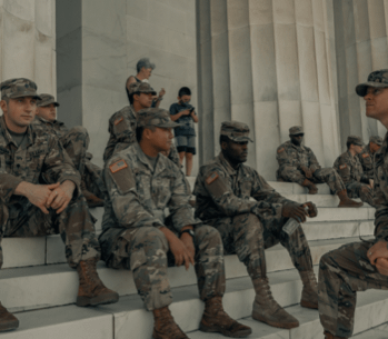 United States Army soldiers sitting on steps next to marble pillar