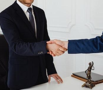 two people in suits shaking hands