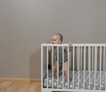 a baby standing in a crib