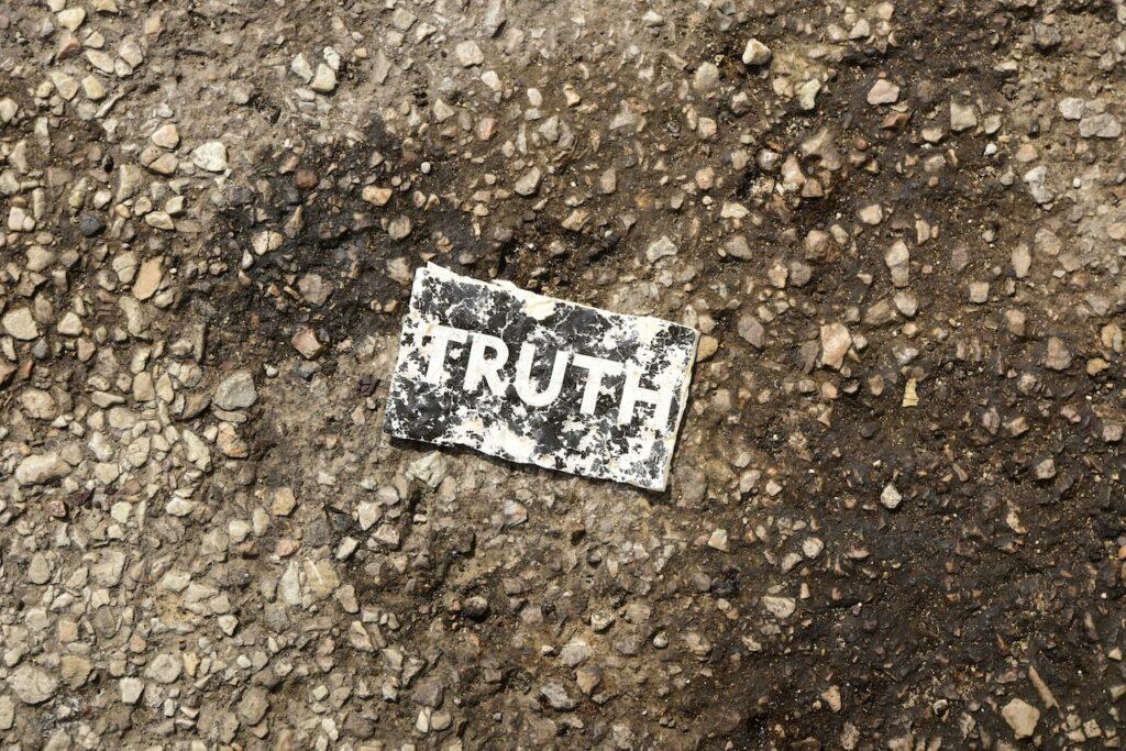 a piece piece of paper on the ground with the word "truth" printed on it