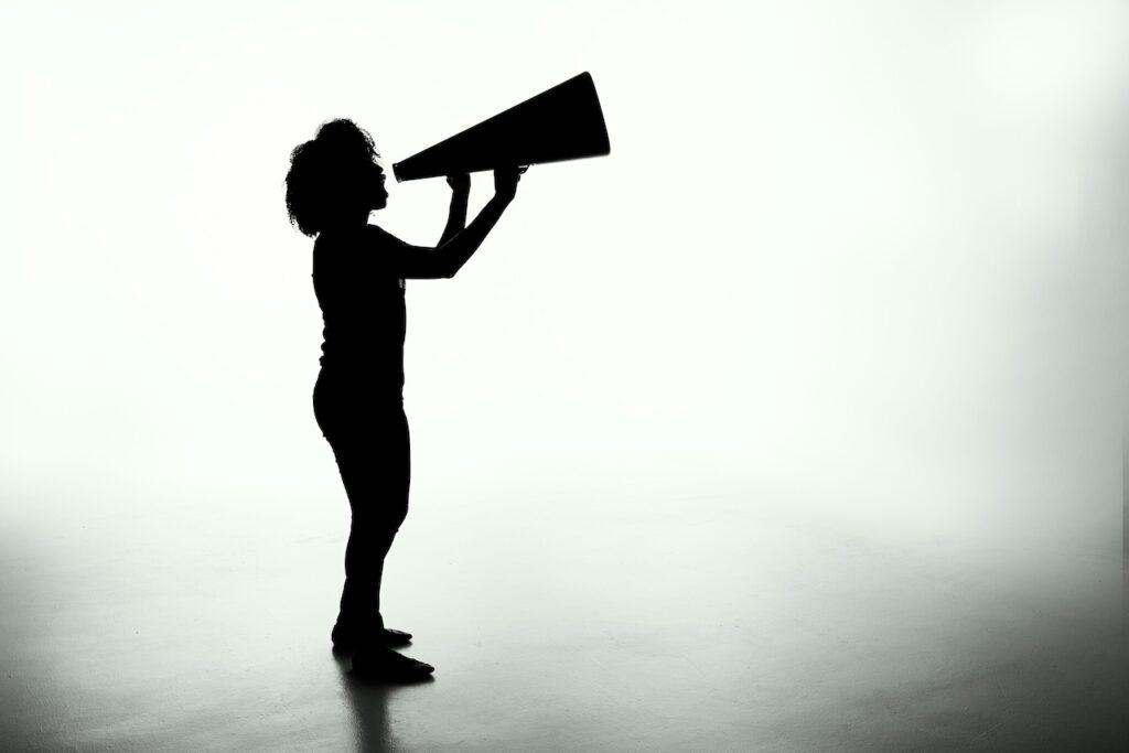 silhouette of a person speaking into a megaphone