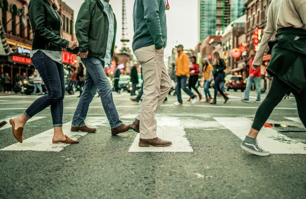 a crowd of people walking on a pedestrian crossing